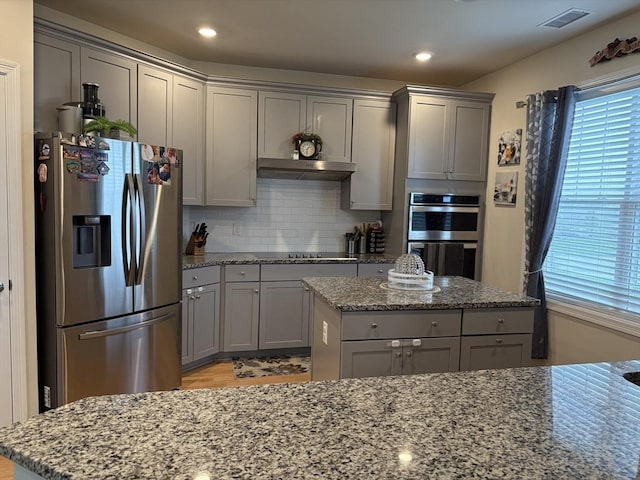 12101 Peters Farm Way Unit 12101, Westborough, MA 01581 - kitchen with stainless steel appliances, gray cabinetry, backsplash, light stone counters, and recessed lighting