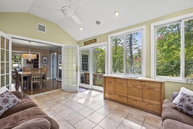 living area with vaulted ceiling, ceiling fan, and light tile patterned flooring