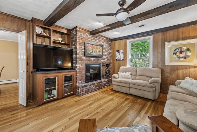 living area featuring a baseboard radiator, hardwood / wood-style flooring, beamed ceiling, wooden walls, and ceiling fan