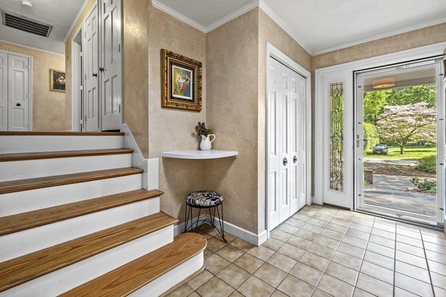foyer entrance featuring light tile patterned floors, stairway, crown molding, and baseboards