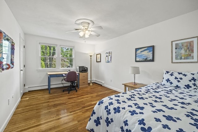 bedroom featuring baseboard heating, wood finished floors, baseboards, and a ceiling fan