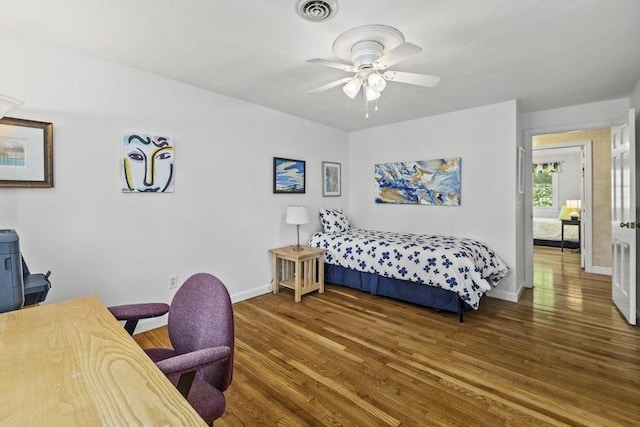 bedroom featuring wood finished floors, baseboards, and ceiling fan
