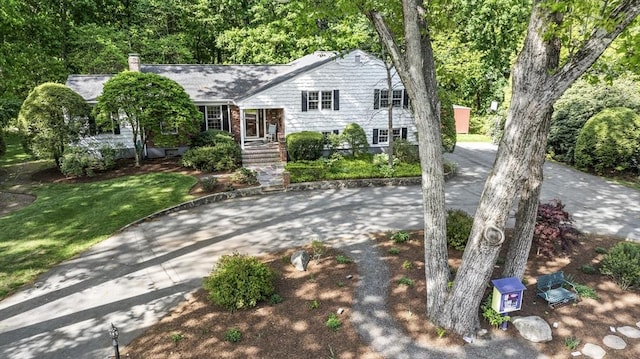 split level home with driveway, a chimney, and a front yard