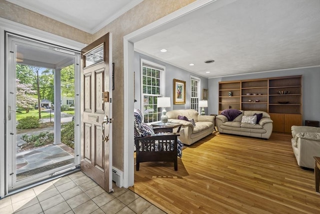 entrance foyer with crown molding, light wood-style flooring, and baseboard heating