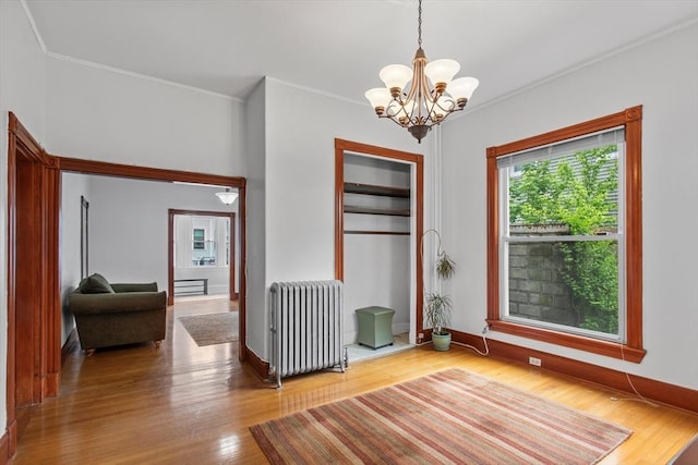 38 Torrey St, Boston, MA 02124 - spare room with radiator, a chandelier, wood finished floors, ornamental molding, and baseboards