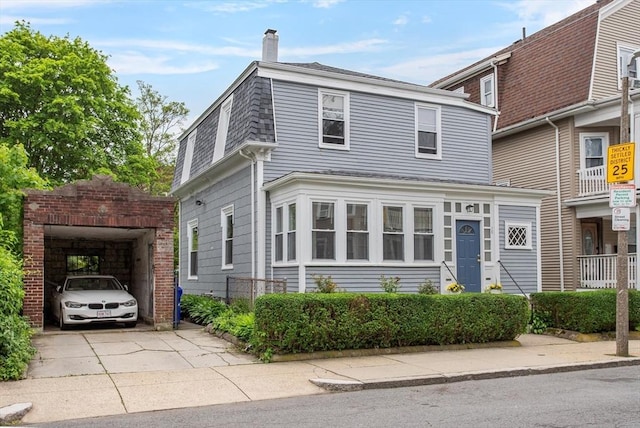 38 Torrey St, Boston, MA 02124 - view of front facade with a chimney, driveway, and a garage