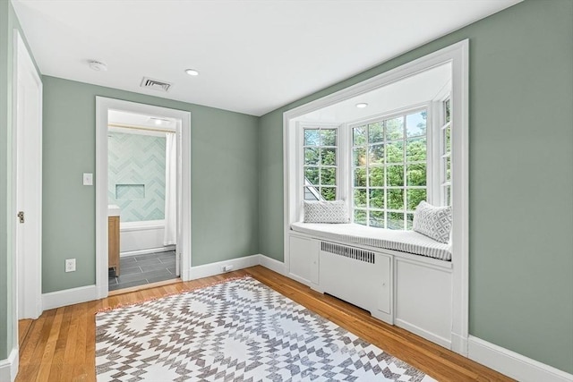 4 Worthen Rd, Winchester, MA 01890 - bedroom with radiator heating unit, light wood finished floors, baseboards, ensuite bathroom, and recessed lighting