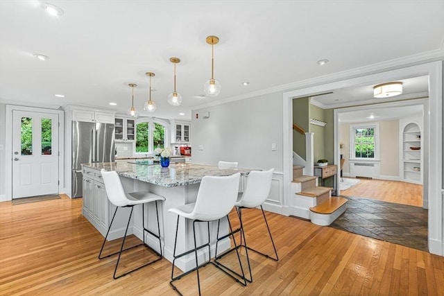 4 Worthen Rd, Winchester, MA 01890 - kitchen with stainless steel fridge, light wood finished floors, white cabinets, glass insert cabinets, and a center island