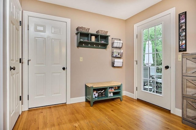 doorway with light wood-style flooring and baseboards