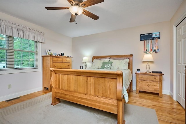 bedroom with light wood-type flooring, baseboards, and ceiling fan