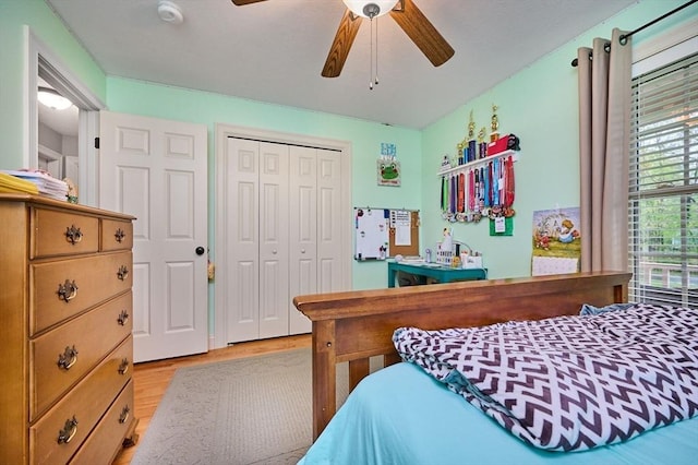 bedroom with light wood finished floors, a closet, and ceiling fan