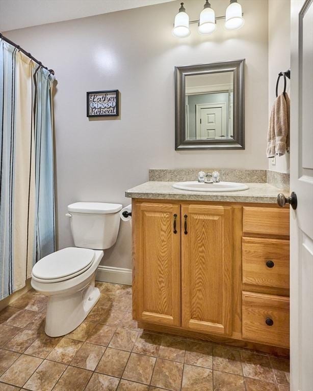 full bath featuring toilet, vanity, baseboards, and curtained shower