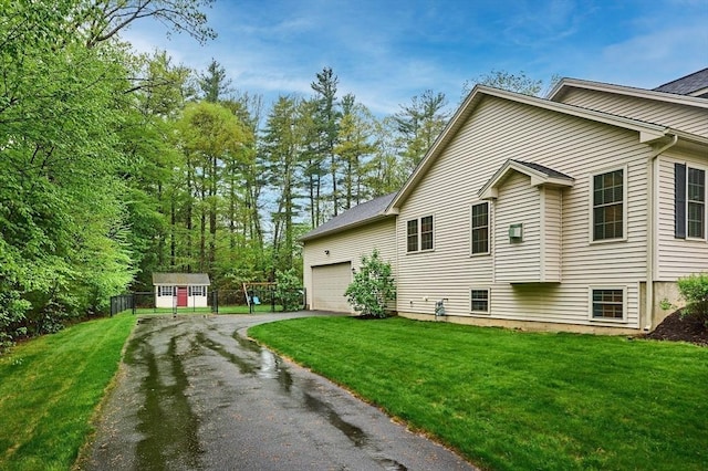 view of home's exterior with asphalt driveway and a garage