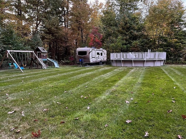 view of green lawn featuring a playground and an outdoor pool