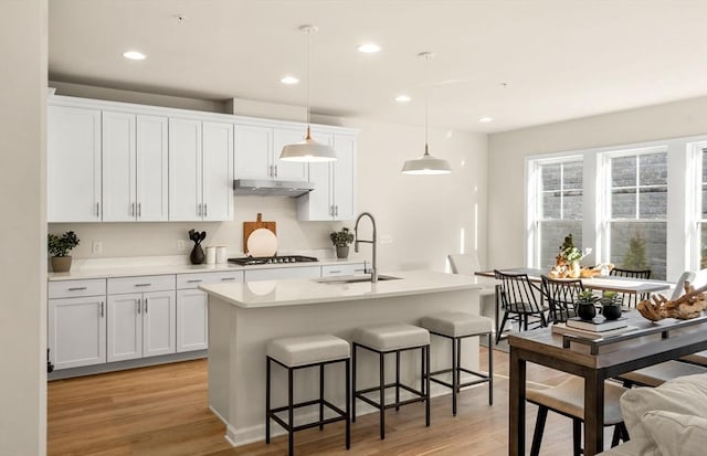 15 Mason Way Unit 73, Woburn, MA 01801 - kitchen with under cabinet range hood, gas cooktop, light wood finished floors, a breakfast bar, and recessed lighting