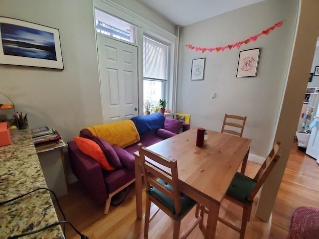 dining room with baseboards and light wood finished floors