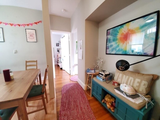 corridor with light wood-style floors and baseboards