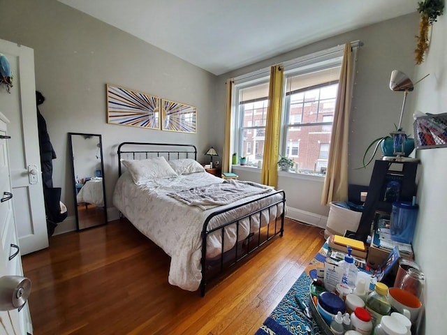 bedroom with baseboards and hardwood / wood-style flooring