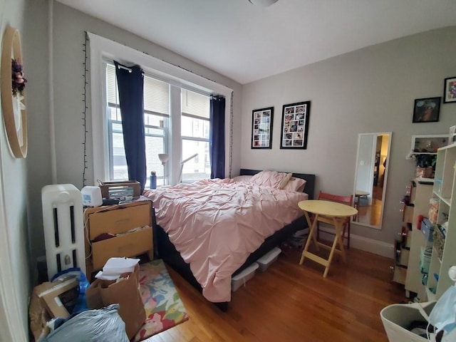 bedroom with wood finished floors and baseboards