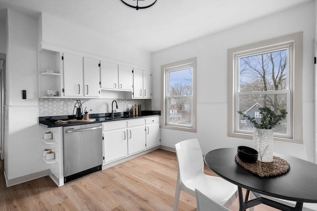 kitchen with backsplash, stainless steel dishwasher, light wood-style flooring, and open shelves