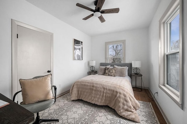 bedroom with light wood-style floors, baseboards, and ceiling fan