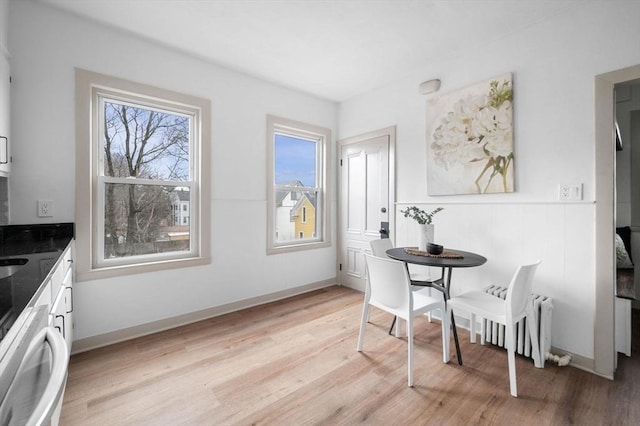 dining area featuring baseboards and light wood-type flooring