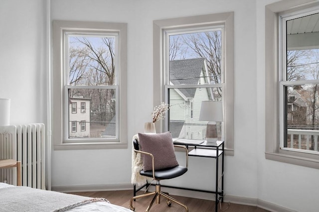 bedroom featuring radiator, baseboards, and wood finished floors