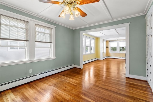 7 Coolidge Rd, Danvers, MA 01923 - empty room featuring a baseboard heating unit, a ceiling fan, wood finished floors, baseboards, and crown molding
