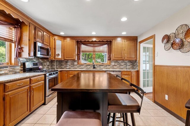 7 Coolidge Rd, Danvers, MA 01923 - kitchen with stainless steel appliances, a sink, healthy amount of natural light, light tile patterned floors, and a wainscoted wall