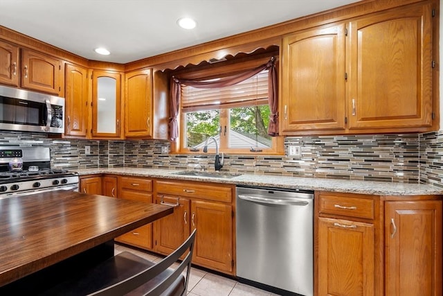 7 Coolidge Rd, Danvers, MA 01923 - kitchen featuring stainless steel appliances, a sink, brown cabinetry, and decorative backsplash