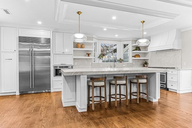 kitchen featuring premium range hood, open shelves, appliances with stainless steel finishes, and white cabinetry