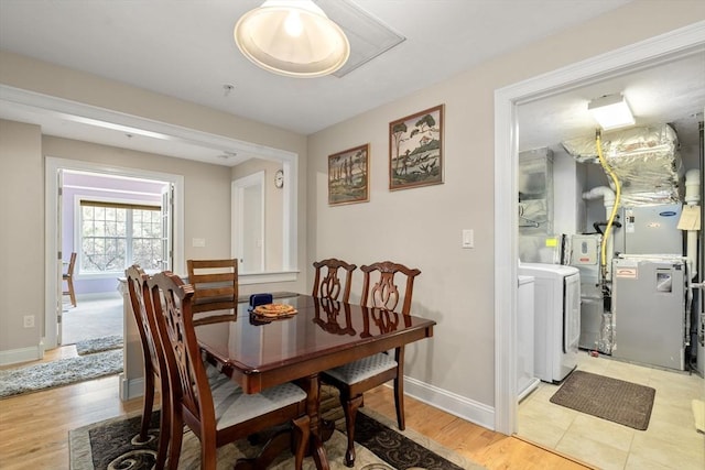 dining area featuring washing machine and dryer and light hardwood / wood-style flooring