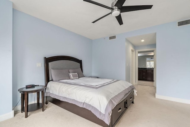 bedroom featuring ceiling fan, ensuite bathroom, and light carpet