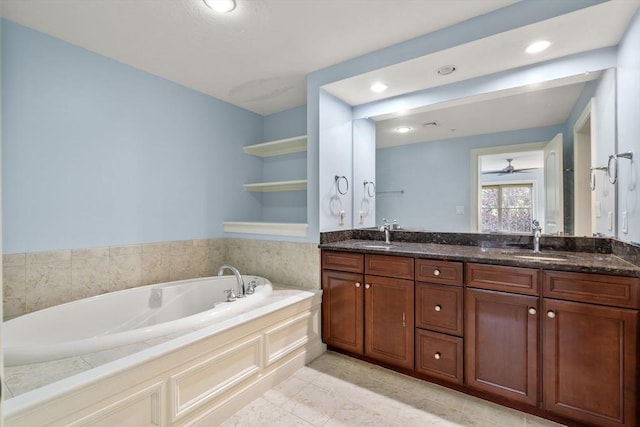 bathroom featuring tile patterned flooring, vanity, and a bath