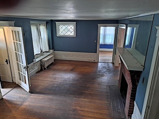 281 Elmwood Ave, Quincy, MA 02170 - unfurnished dining area featuring radiator heating unit, dark wood-style floors, healthy amount of natural light, and a brick fireplace