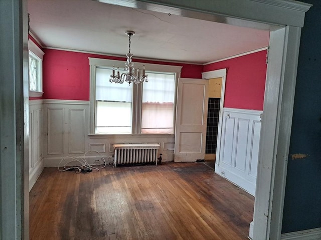 281 Elmwood Ave, Quincy, MA 02170 - dining room with radiator heating unit, wainscoting, wood finished floors, a chandelier, and ornamental molding