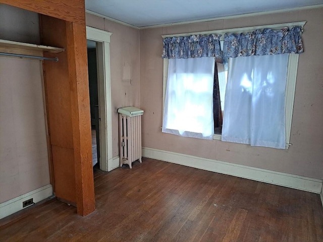 281 Elmwood Ave, Quincy, MA 02170 - unfurnished bedroom with radiator heating unit, wood finished floors, and crown molding