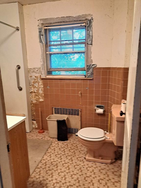 281 Elmwood Ave, Quincy, MA 02170 - full bath featuring tile walls, radiator heating unit, a wainscoted wall, vanity, and a shower