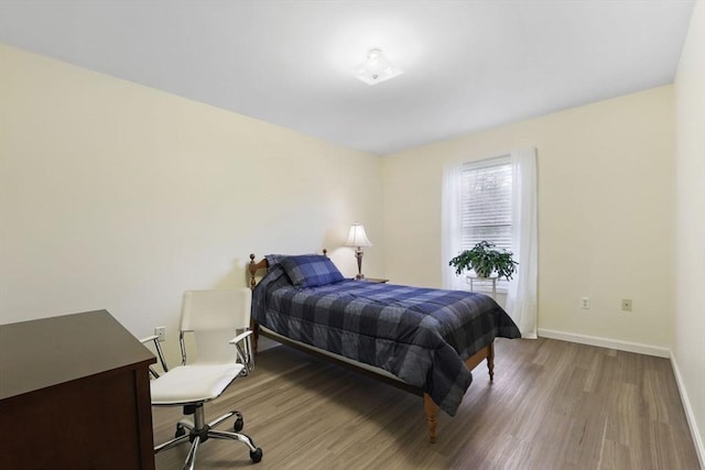 bedroom with wood finished floors and baseboards