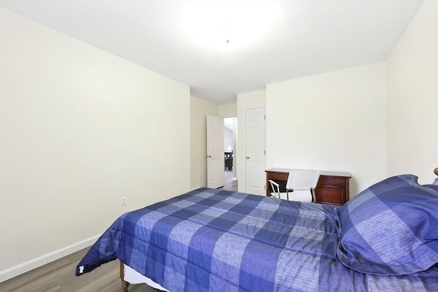 bedroom with wood finished floors and baseboards