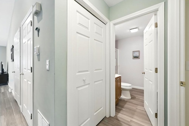 hallway with light wood-style flooring and baseboards