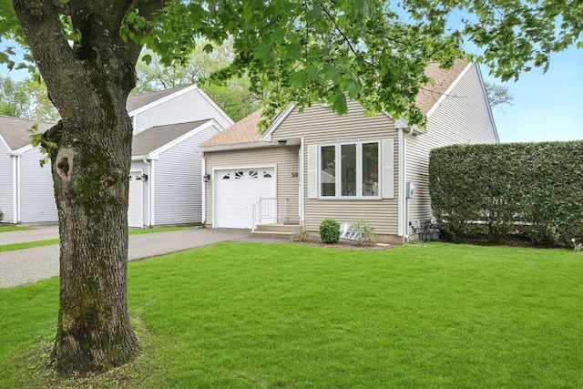 view of front of home featuring an attached garage, a front yard, driveway, and roof with shingles