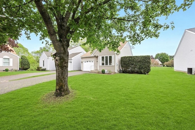 view of front facade featuring concrete driveway, a garage, a front lawn, and central AC