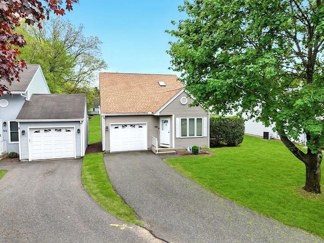 view of front of home with a garage, driveway, and a front lawn