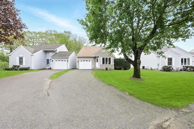 ranch-style house with a garage, driveway, and a front yard
