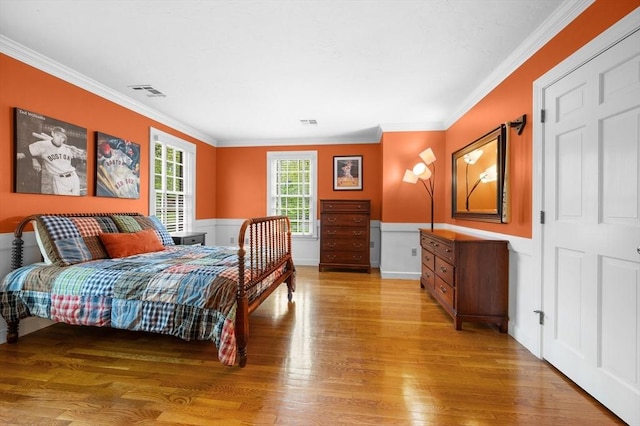 bedroom with light wood-style floors and ornamental molding