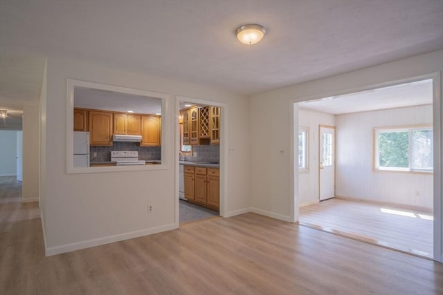 6 Marshall Rd, Beverly, MA 01915 - kitchen featuring white appliances, light wood finished floors, under cabinet range hood, tasteful backsplash, and brown cabinets