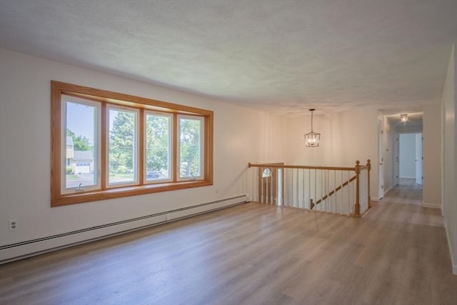 6 Marshall Rd, Beverly, MA 01915 - spare room featuring baseboard heating, wood finished floors, and a chandelier