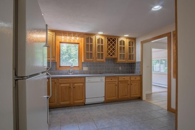 6 Marshall Rd, Beverly, MA 01915 - kitchen featuring freestanding refrigerator, white dishwasher, backsplash, a baseboard heating unit, and glass insert cabinets