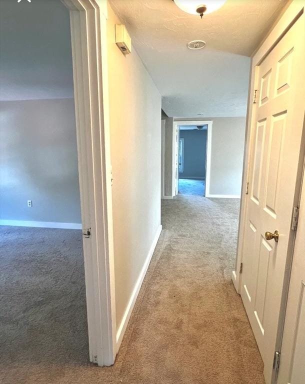 corridor featuring carpet and baseboards